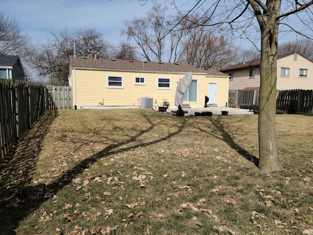 back of house with cooling unit, a lawn, a fenced backyard, and a patio area