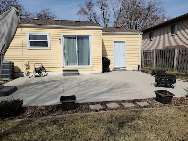 rear view of house featuring a fire pit, fence, central air condition unit, entry steps, and a patio area