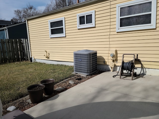 view of property exterior featuring a patio, central AC unit, and fence