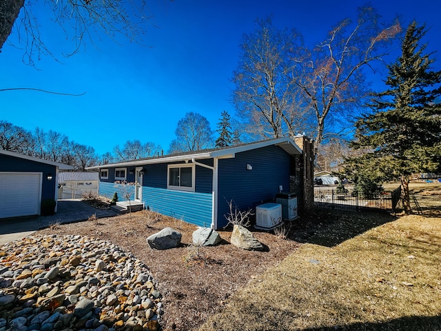 ranch-style home with cooling unit and fence