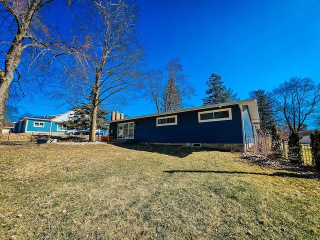 ranch-style home featuring a front lawn and fence