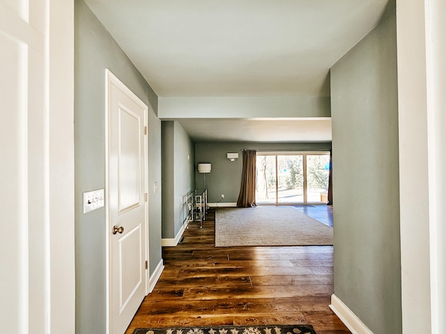 hall featuring baseboards and dark wood-style flooring