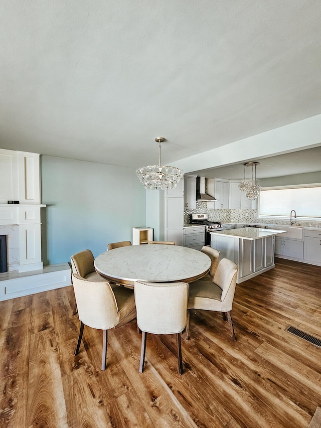 dining space featuring an inviting chandelier, visible vents, and dark wood-style flooring