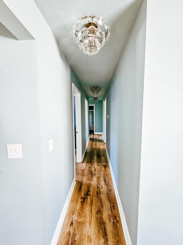 hall featuring baseboards and wood finished floors