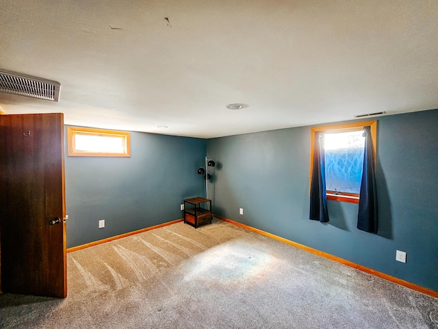 carpeted empty room with visible vents and baseboards