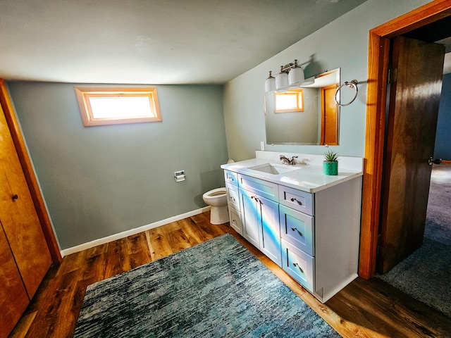 bathroom with baseboards, toilet, wood finished floors, and vanity