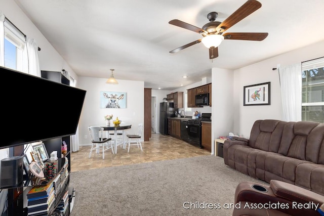 living room featuring recessed lighting, a ceiling fan, light colored carpet, and a healthy amount of sunlight