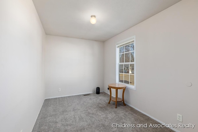 carpeted empty room featuring visible vents and baseboards