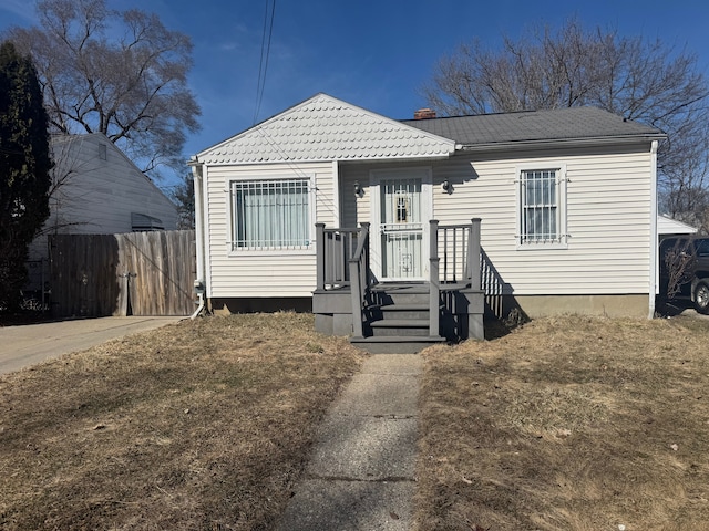 bungalow-style house with fence