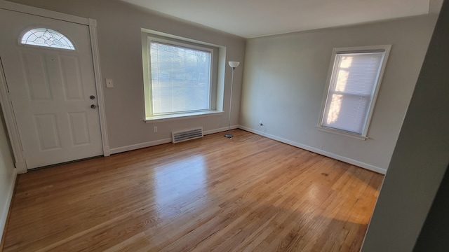 entryway with visible vents, plenty of natural light, baseboards, and light wood finished floors