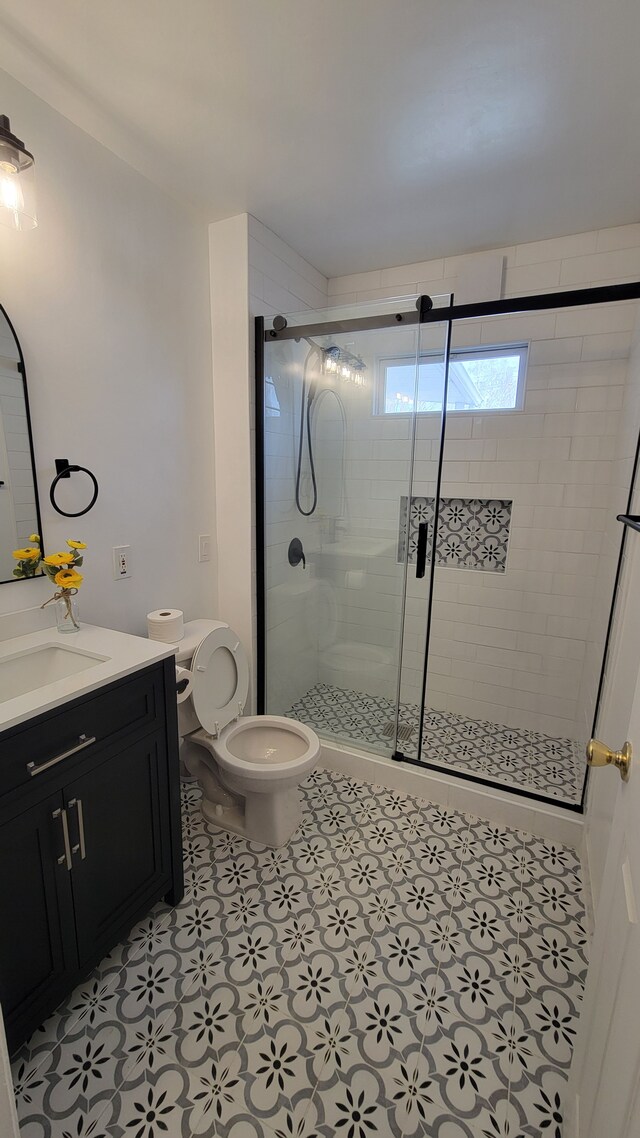 bathroom with vanity, toilet, and a stall shower