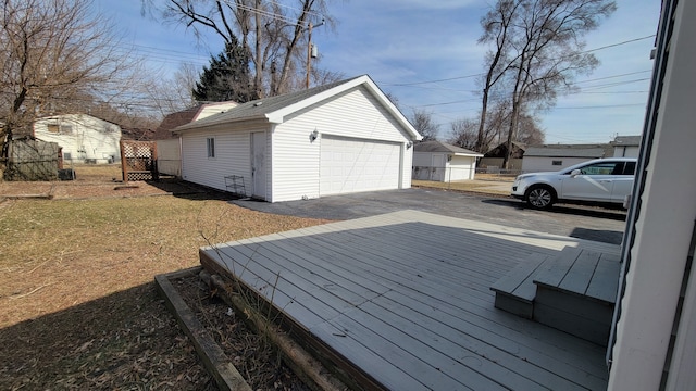 wooden deck with an outbuilding, a yard, and a detached garage