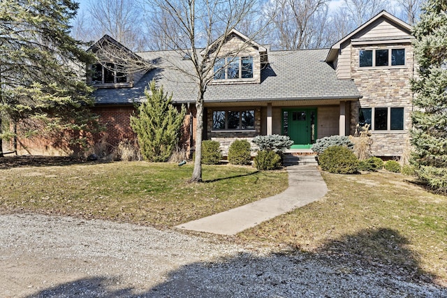 view of front facade with stone siding, a shingled roof, and a front lawn