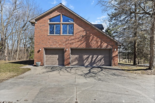 view of home's exterior with brick siding, an attached garage, and concrete driveway