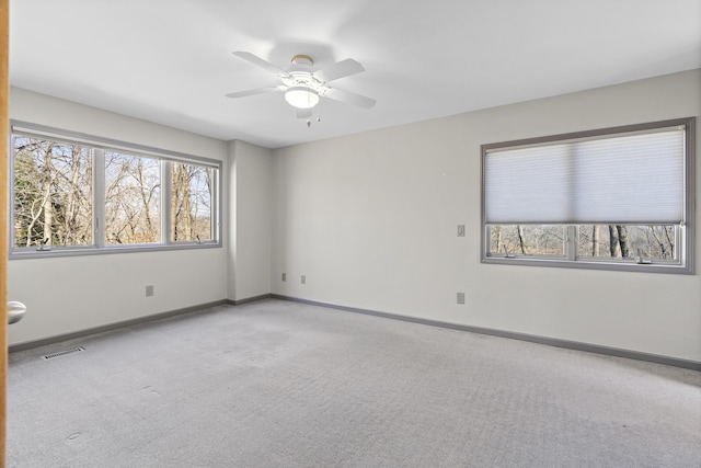 unfurnished room with baseboards, visible vents, carpet floors, and ceiling fan