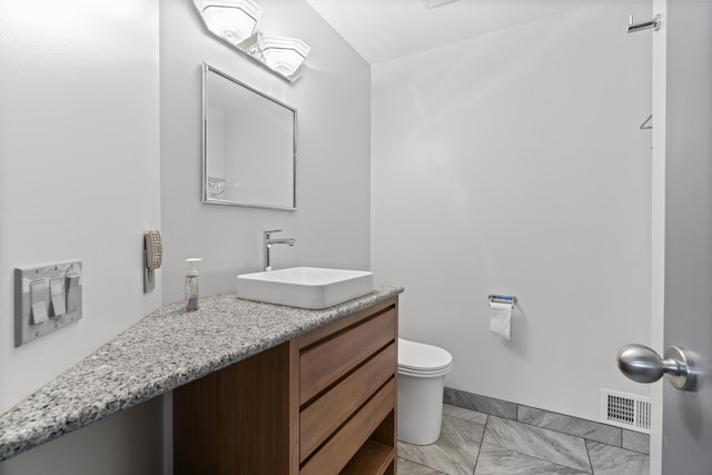 half bathroom with visible vents, toilet, vanity, and marble finish floor