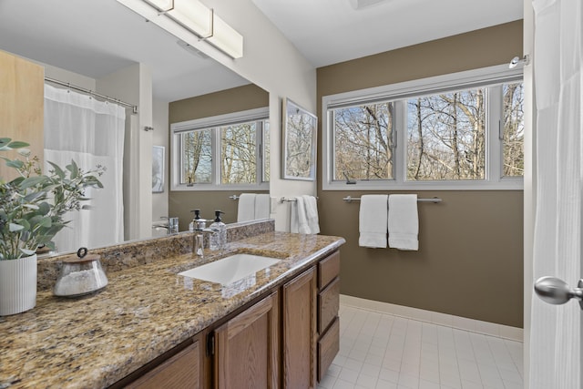 full bath with vanity, tile patterned floors, and baseboards