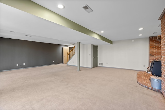 finished basement featuring recessed lighting, visible vents, light colored carpet, and stairway