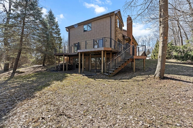 rear view of property with a chimney, a deck, and stairs