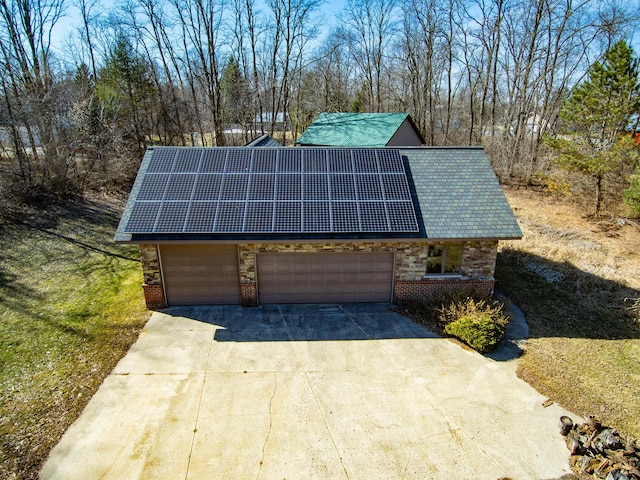 exterior space with brick siding, solar panels, concrete driveway, and a garage