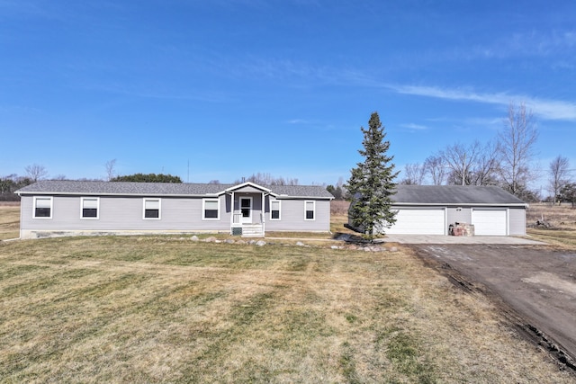 view of front of property with aphalt driveway, an outbuilding, and a front lawn