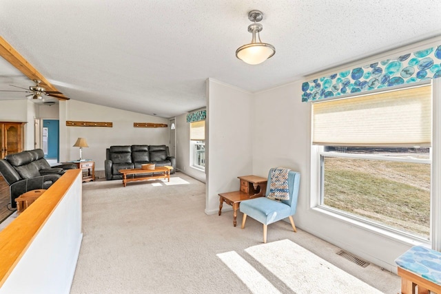 living room featuring visible vents, a textured ceiling, carpet flooring, ceiling fan, and vaulted ceiling