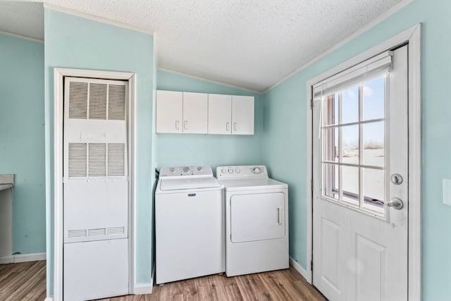 laundry room with light wood-style flooring, a healthy amount of sunlight, independent washer and dryer, and a textured ceiling