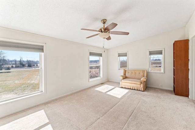 unfurnished room featuring lofted ceiling, a healthy amount of sunlight, and ceiling fan