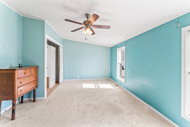 carpeted bedroom with baseboards, a textured ceiling, and ceiling fan