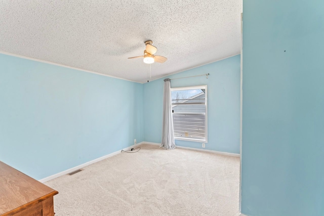 carpeted empty room featuring visible vents, baseboards, a textured ceiling, and a ceiling fan