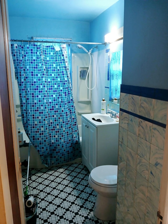 full bathroom with vanity, tile walls, toilet, and shower / bathtub combination with curtain