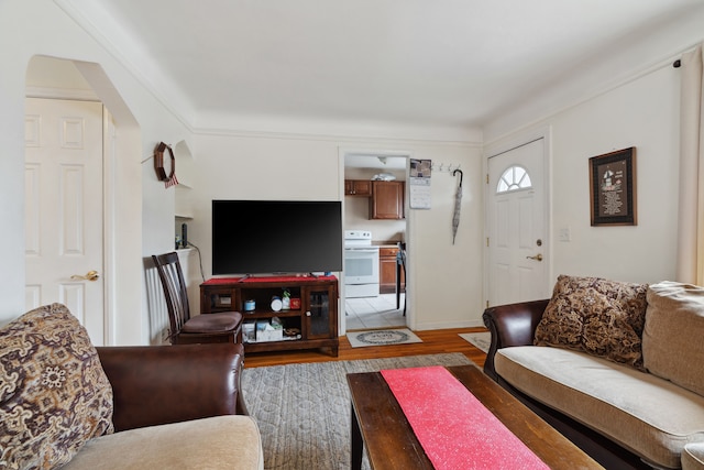 living area featuring arched walkways and light wood finished floors