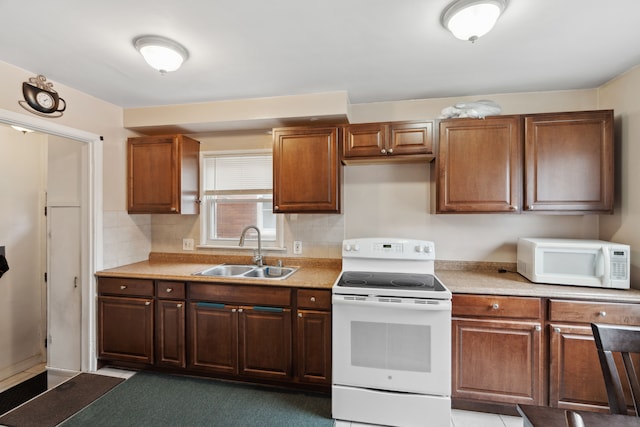 kitchen with white appliances, light countertops, tasteful backsplash, and a sink