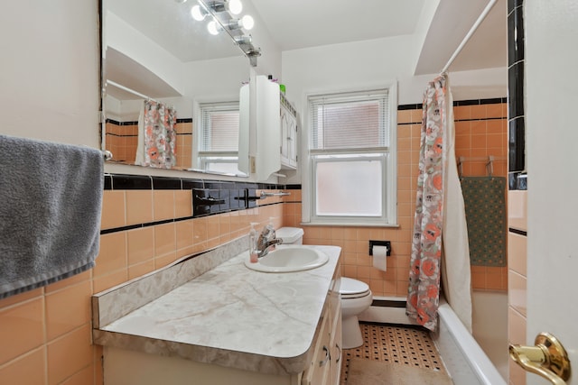 full bath with toilet, shower / bath combo, a baseboard heating unit, tile walls, and vanity