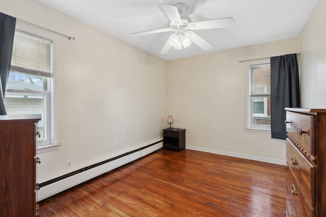 unfurnished bedroom with a ceiling fan, wood-type flooring, baseboards, and a baseboard radiator