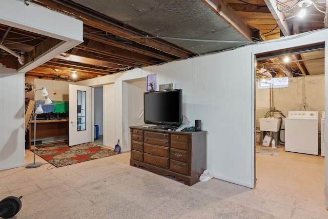 below grade area featuring washing machine and clothes dryer and a sink