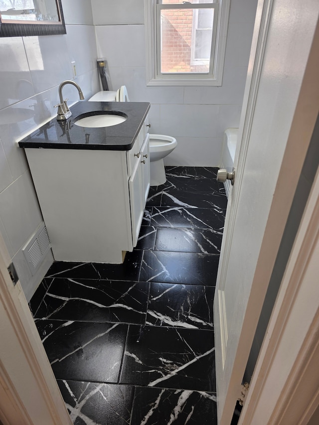 bathroom with visible vents, toilet, marble finish floor, and vanity