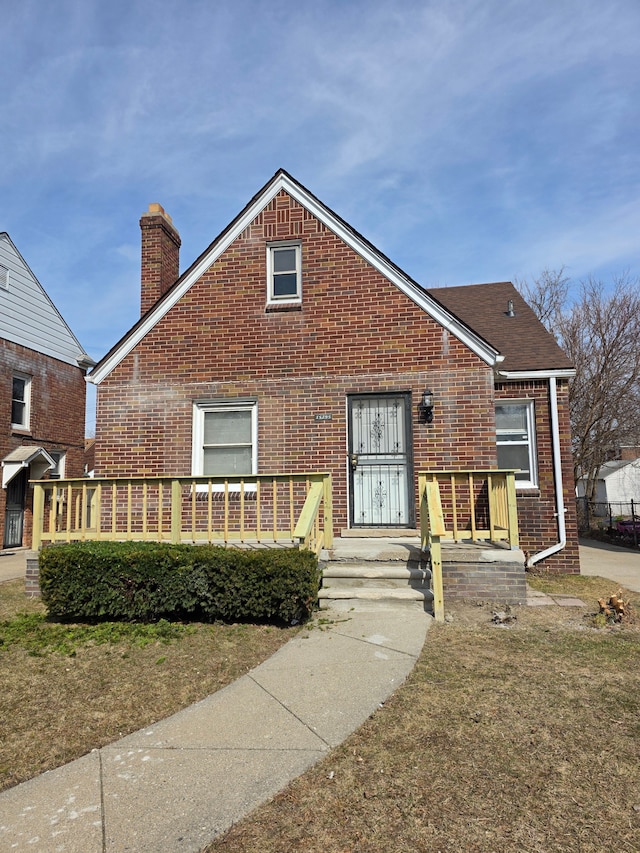 view of front of house featuring brick siding and a chimney