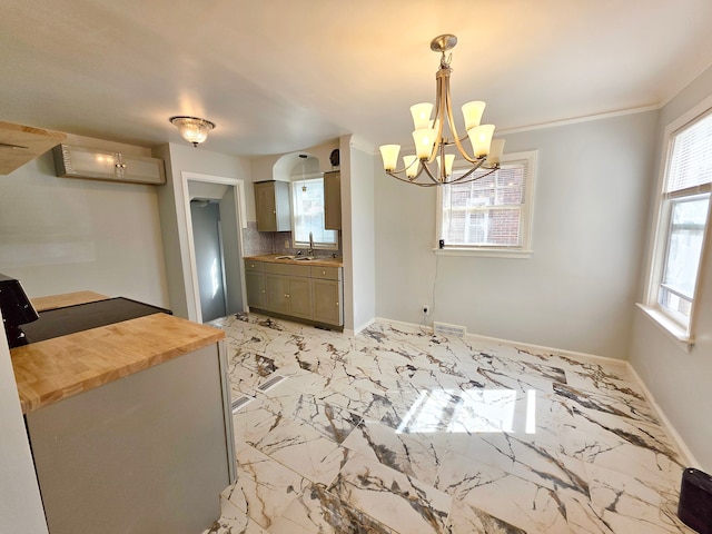 kitchen featuring marble finish floor, a sink, wood counters, backsplash, and baseboards