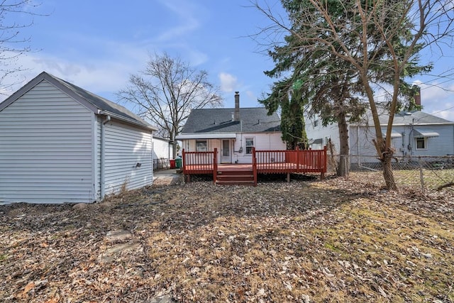 back of property with a wooden deck and fence