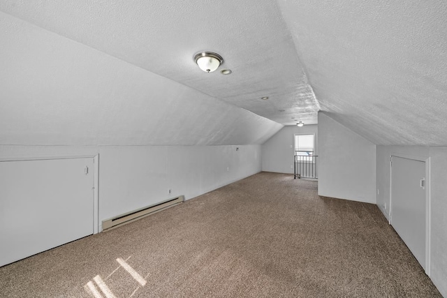 additional living space with baseboard heating, carpet flooring, a textured ceiling, and lofted ceiling