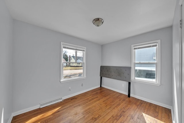 unfurnished bedroom featuring baseboards, visible vents, and wood-type flooring