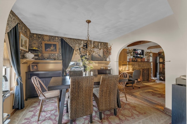 dining room with arched walkways and a notable chandelier