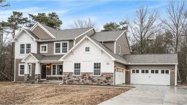 view of front facade with concrete driveway, an attached garage, stone siding, and a shingled roof