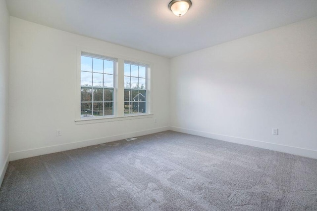 carpeted empty room featuring baseboards