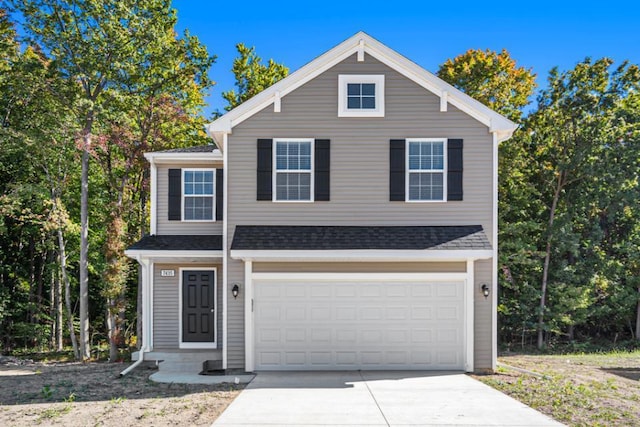 view of front of home featuring a garage, driveway, and a shingled roof