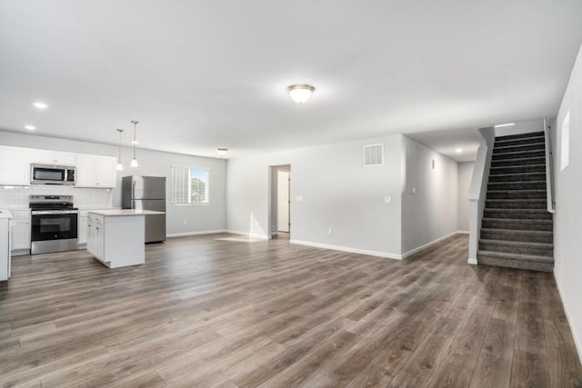 unfurnished living room featuring visible vents, dark wood-style floors, recessed lighting, baseboards, and stairs