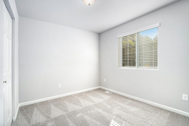 carpeted empty room with baseboards