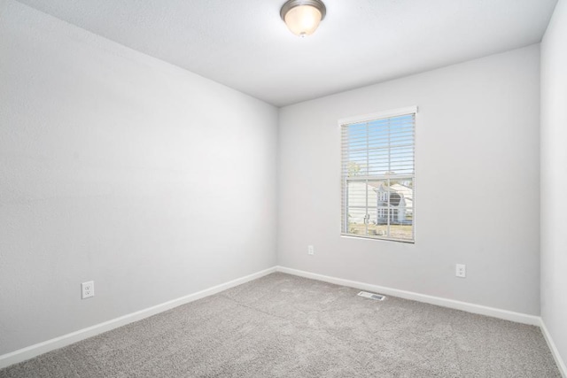 carpeted spare room with baseboards and visible vents