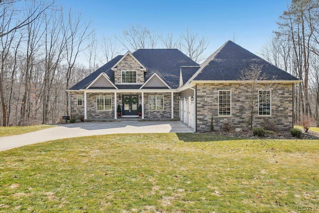 back of property featuring french doors, a garage, a yard, stone siding, and driveway